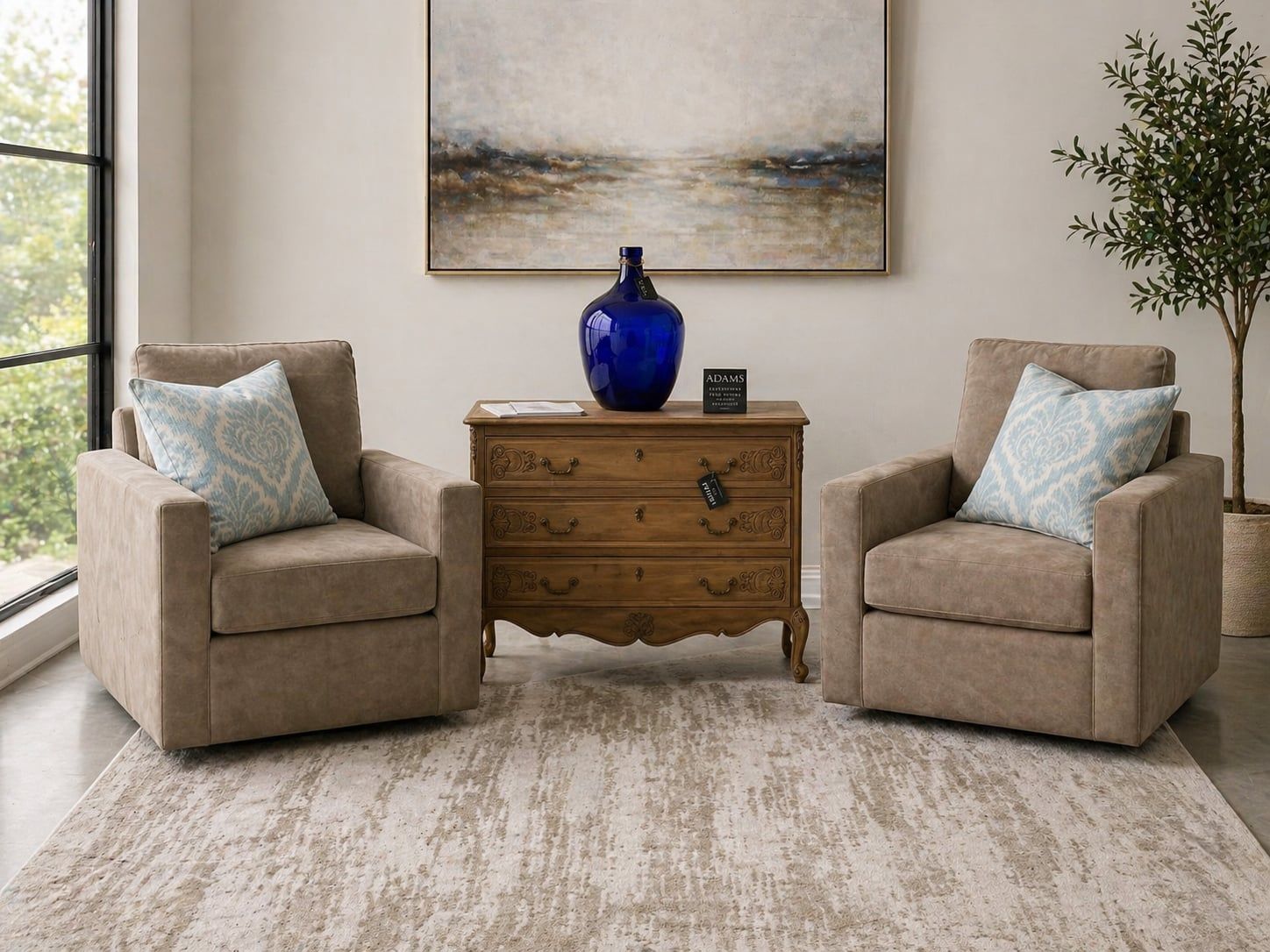 Pair of beige tweed armchairs flanking a carved wood chest with cobalt vessel