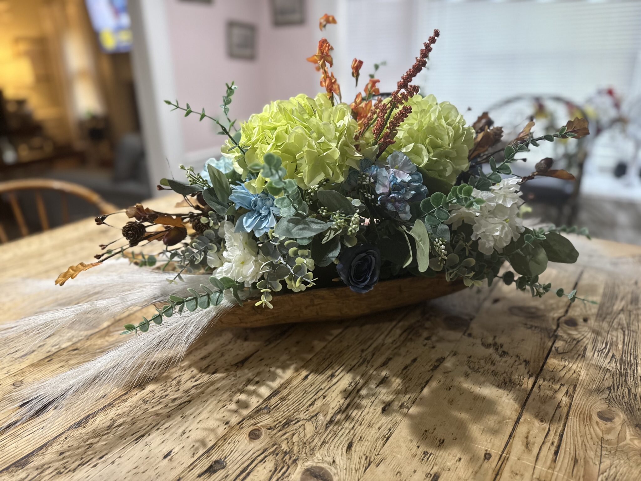 Floral centerpiece on rustic wood dining table