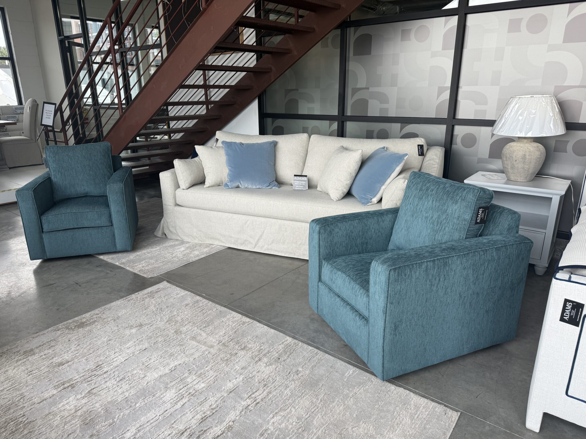 Cream sofa flanked by teal armchairs